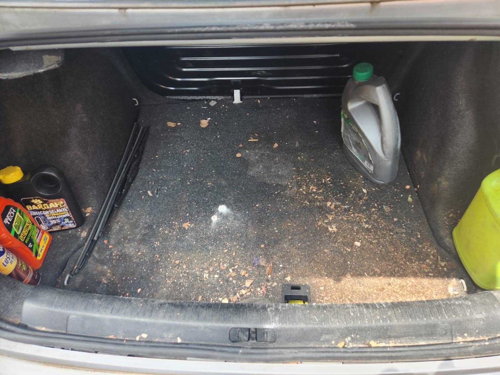 Cajuela de auto con polvo y residuos antes de limpieza de interior en CDMX