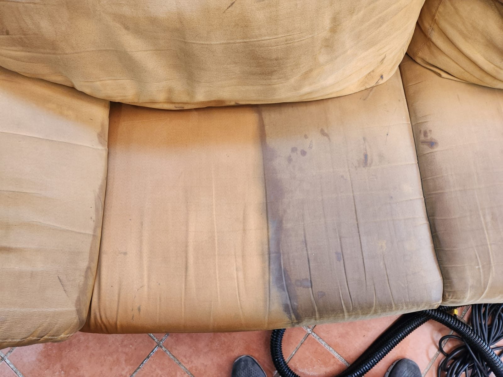 Cojines de sala en proceso de limpieza mostrando la diferencia entre tela limpia y sucia