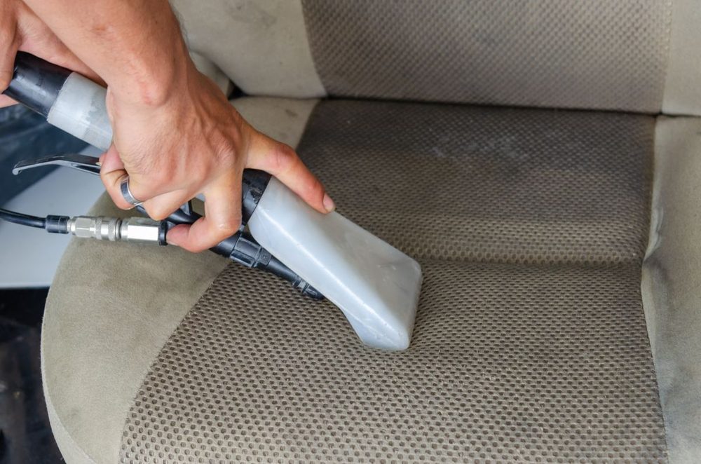 Extracción profunda con máquina profesional sobre tela de asiento, resultado de desinfección de tapicería