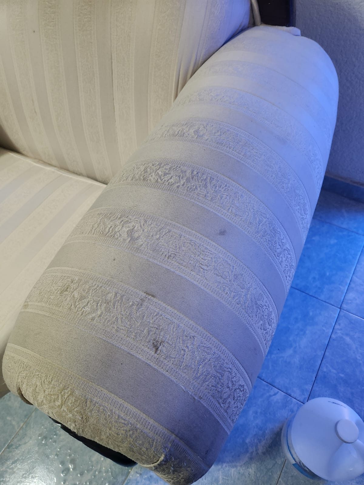 Sillón tapizado en tela clara con manchas visibles antes de limpieza profesional en CDMX